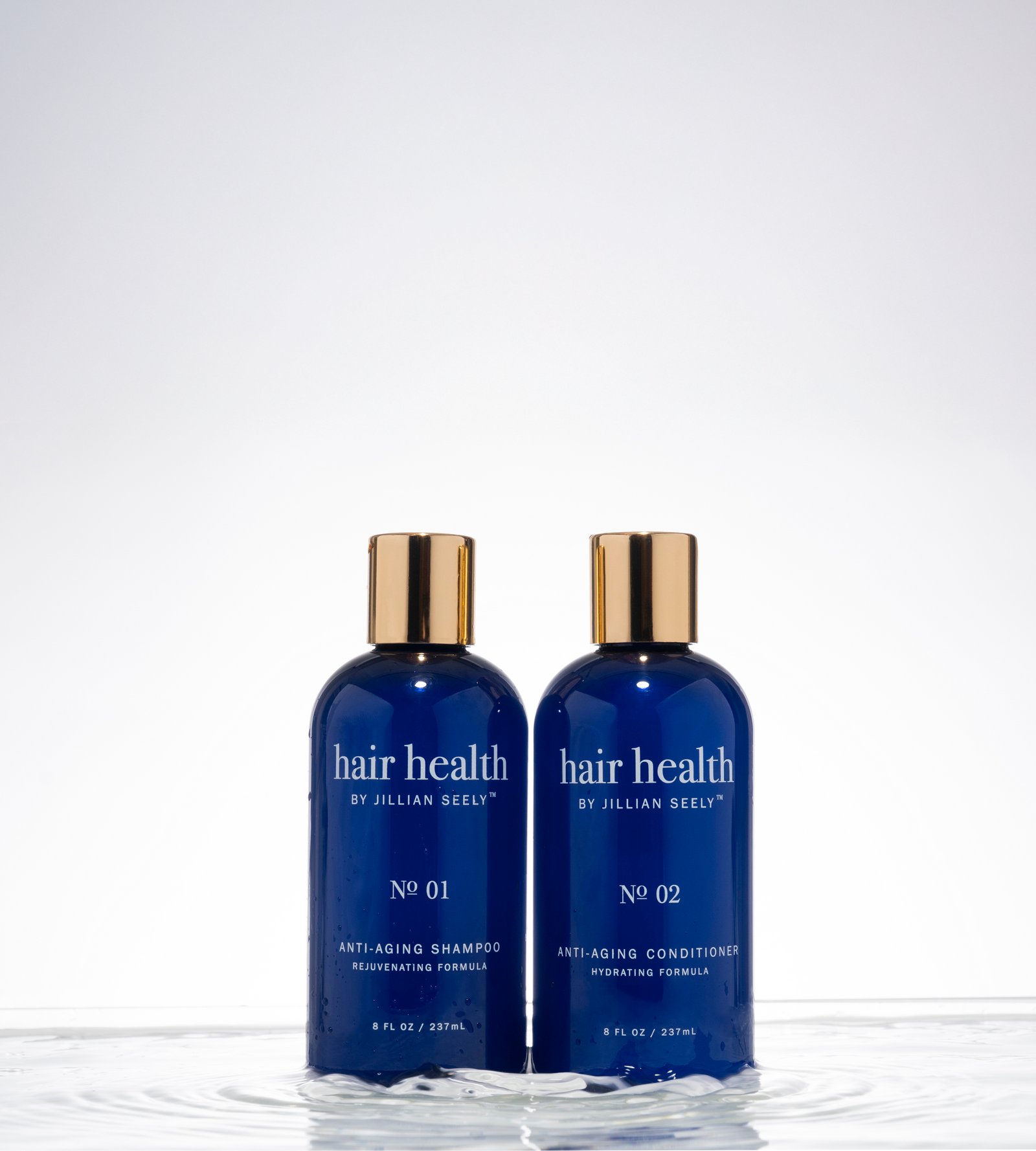 Two blue bottles of 'hair health by Jillian Seely' on a white background